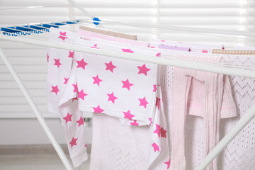 Different apparel drying on clothes airer indoors, closeup