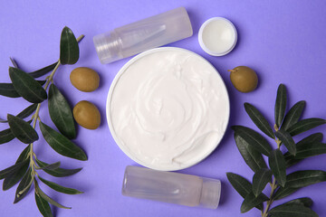 Different cosmetic products and olives on violet background, flat lay