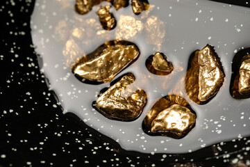 Fototapeta na wymiar Pile of shiny gold nuggets in water, closeup view