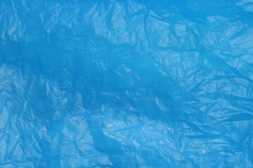 Crumpled light blue plastic bag as background, top view