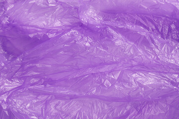 Crumpled purple plastic bag as background, top view