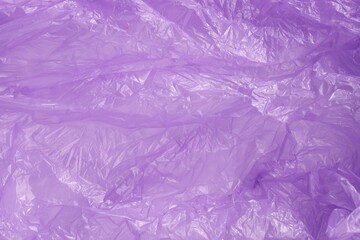 Crumpled purple plastic bag as background, top view