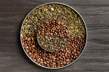 Green tea and coffee grains on a dark wooden background top view.