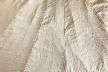 Fototapeta na wymiar Crumpled dark beige fabric as background, top view