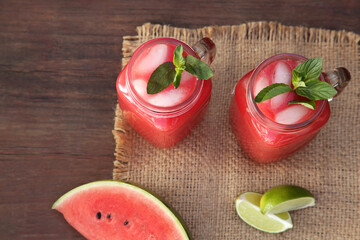Delicious watermelon drink and fresh fruits on wooden table, above view
