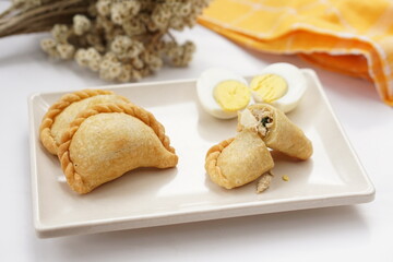 Indonesian snack called pastel. It filled with meat, vegetables, egg, and rice vermicelli. Deep fried in vegetable oil. Commonly sold in traditional market. 