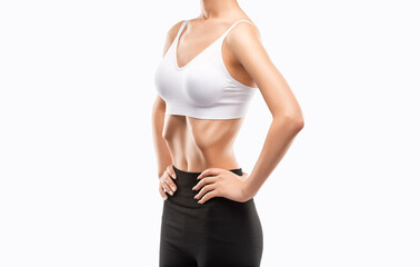 Young woman in black and white sportswear working out her abdominal muscles. Beautiful sporty woman is exercising and doing fitness, belly vacuum.