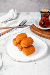 Tulumba dessert. Ramadan sweets. Traditional Turkish cuisine delicacies. Tulumba dessert with syrup on a gray background.