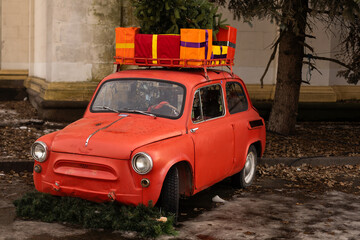 Car with trunk full of gift boxes, presents and fir tree for Christmas. Car, presents, craft box, snow, holidays. Street outdoor
