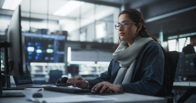 Portrait of a Thoughtful South Asian Engineer Working on Computer in a Technological Corporate Office. Young Woman Writing Software Code for an Innovative Internet and Software as a Service Project