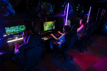 Team of gamers playing video game on tournament in cybersport club