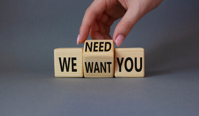 We need and want You symbol. Businessman Hand turns cubes and changes word We want you to We need you. Beautiful grey background. Business and We need and want You concept. Copy space