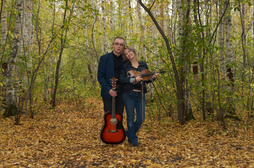 A couple of musicians sing and dance in the autumn park