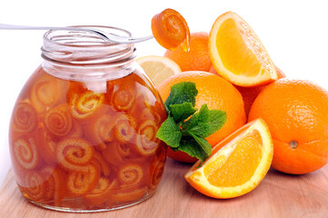 orange jam in a jar on a white background.