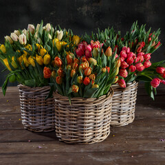 wicker baskets with tulips on a wooden floor