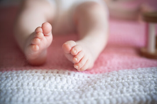 Baby's feet on a pink and white blanket