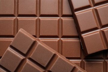Delicious milk chocolate bars as background, top view