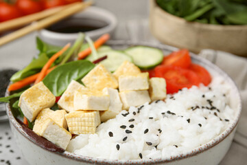 Delicious poke bowl with vegetables, tofu and mesclun, closeup