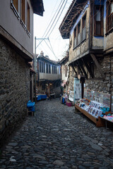 Fototapeta na wymiar Narrow street in the old town of Bursa, Turkey. Local sales products stand.