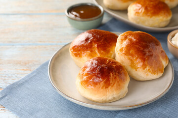 Tasty scones prepared on soda water and chocolate paste on wooden table, space for text