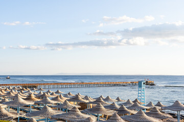 Obraz premium straw beach umbrella with blue sky.