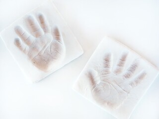 baby handprints on white dry clay. Memorias of a baby - obrazy, fototapety, plakaty