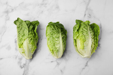 Fresh green romaine lettuces on white marble table, flat lay