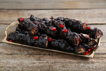 Tray with delicious sweet churchkhelas on wooden table
