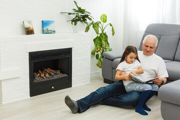 Senior man showing photos to his granddaughter