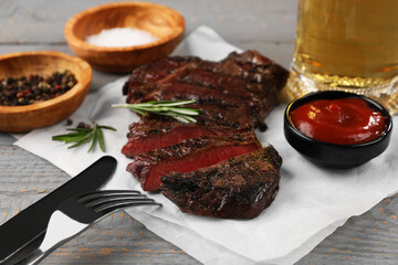 Delicious fried steak served on grey wooden table, closeup