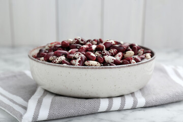 Bowl with dry kidney beans on table, closeup
