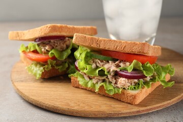 Delicious sandwiches with tuna and vegetables on light grey table