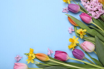 Beautiful flowers on light blue background, flat lay. Space for text