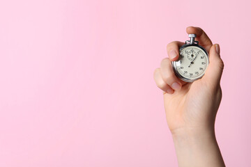 Woman holding vintage timer on pink background, closeup. Space for text