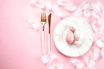 Colorful easter eggs and white plate on pink background. Happy Easter holiday concept