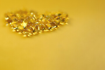 Cod liver oil omega 3 gel capsules - heart shape, keto diet, isolated on pastel background. Top view, copy space, high resolution product. Health care concept