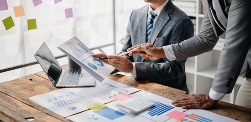 Business People Talking Discussing with financial document data charts and graphs Team business meeting with smart phone and laptop and digital tablet computer