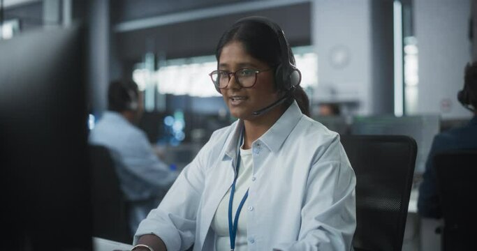 Portrait of a Help Desk Specialist Having a Conversation on a Call, Providing Technical Support to Client Experiencing Software Issues. Indian Female Using a Headset to Talk with a Tech Team