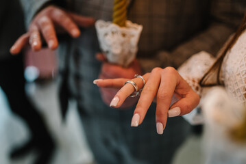 Engagement. The process of exchanging wedding rings. Tradition at the wedding ceremony in a church. Wedding day. Hands with wedding rings. Close up.
