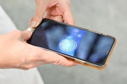 Hand holding smartphone checking your daily horoscope. Astrological zodiac horoscope Mobile application . Spiritual new age, wheel of fortune, fate karma and destiny