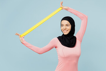 Smiling young asian muslim fitness trainer sporty woman wear pink abaya hijab spend time in home...