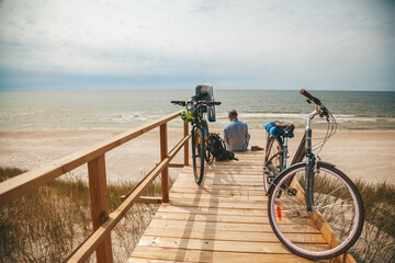 Two bicycles with child seat parked near the beach