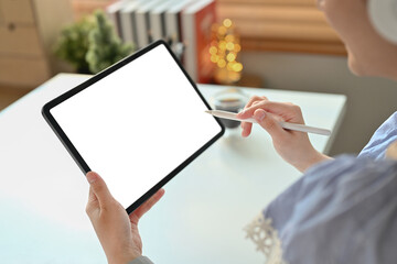 Close up view of creative woman hand holding stylus pen and pointing at blank display of digital tablet