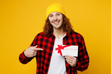 Young man wear red checkered shirt white t-shirt hat hold point index finger on gift certificate...