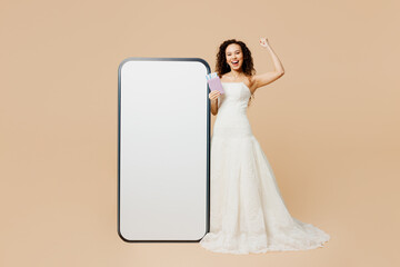 Traveler young woman bride wear wedding dress hold passport ticket big blank screen mobile cell...