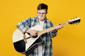 Young smiling satisfied happy man with down syndrome wear glasses casual clothes play guitar sing...