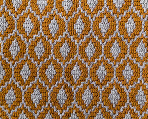 Yellow grey mosaic crochet texture. Ellipse shaped repeating pattern. Knitted background.