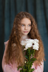 close-up portrait of a girl in a pink dress with white chrysanthemums