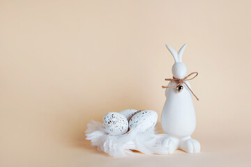 Obraz premium Easter card with white bunny and Easter eggs on light beige background, greeting card with copy space