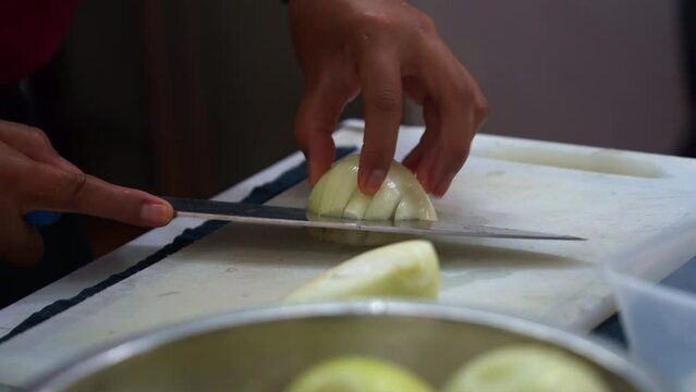 Close up shot of a professional kitchen hand preparing the ingredients for restaurant operation, brunoise cut the onion.